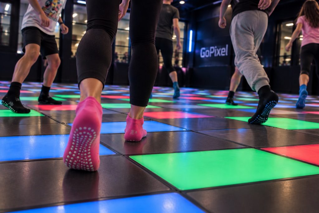 Gros plan sur des joueurs pieds nus en chaussettes sur la piste lumineuse GoPixel